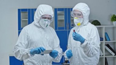 Bilim adamı laboratuarda test tüpüyle selfie çekiyor. 