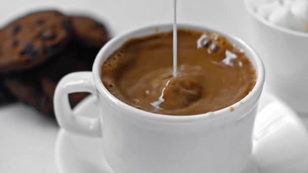 Nahaufnahme Von Milch Die Einer Tasse Kaffee Auf Weiß Gegossen — Stockvideo