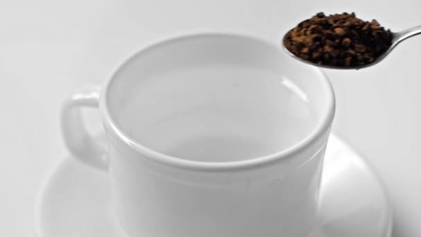 ralenti de l'homme versant café instantané dans une tasse avec de l'eau isolée sur blanc
