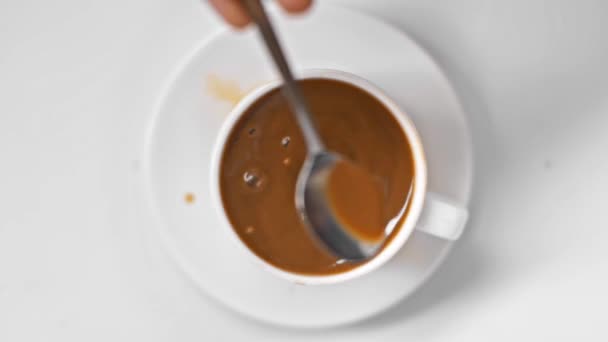 focus pull de l'homme tenant cuillère près du café dans la tasse sur blanc 