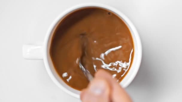 vue de dessus de l'homme en remuant café avec cuillère sur blanc