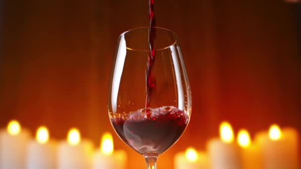 Czerwone Wino Wlewające Się Kieliszka Płonącymi Świecami Tle — Wideo stockowe