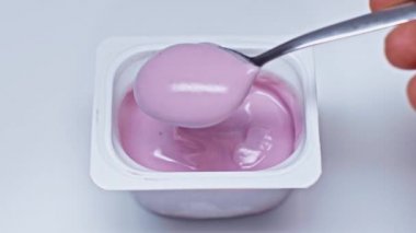 Beyaz yoğurtlu kaşığın yanında duran adamın kırpılmış görüntüsü