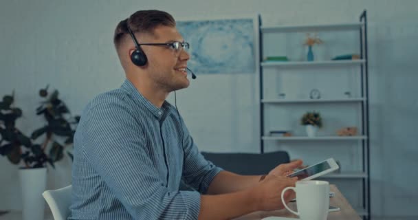 Operador Feliz Auriculares Hablando Utilizando Tableta Digital Beber Café — Vídeo de stock