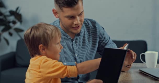 Veselý Otec Ukazující Notebook Roztomilému Synovi Doma — Stock video