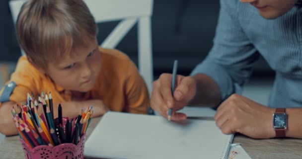 父亲和儿子用彩色铅笔在纸上画画的选择性焦点 — 图库视频影像