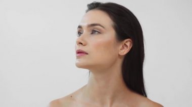 Gri renkli kameraya gülümseyen güzel çıplak kadın.