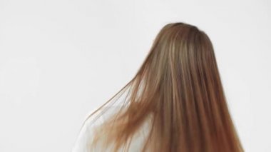 Gri renkte başını sallayan genç bir kadının arka görüntüsü