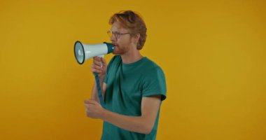 Gözlüklü duygusal kızıl adam sarı hoparlörden izole edilmiş.