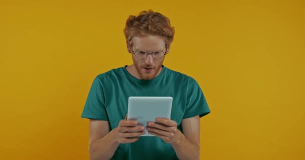 Scossa Rossa Uomo Occhiali Utilizzando Tablet Digitale Isolato Giallo — Video Stock