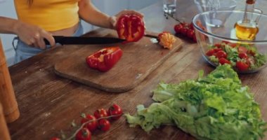 Kırmızı dolmalık biberi salatayla karıştıran kadın manzarası.