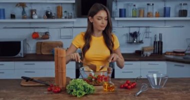 Mutfakta taze salata karıştıran mutlu kadın. 