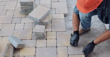 İnşaat alanında kaldırım taşlarıyla çalışan inşaatçı