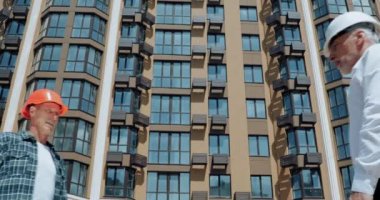 İnşaat alanında gülümseyen mühendis ve inşaatçı el sıkışması