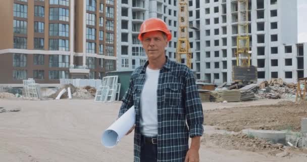 Constructor Sosteniendo Plano Sonriendo Cámara Sitio Construcción — Vídeo de stock