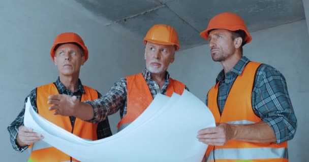 Costruttori Parlando Mentre Tenendo Cianografie Sul Cantiere — Video Stock