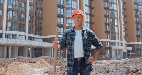 Uśmiechnięty Budowniczy Trzyma Łopatę Pokazuje Kciuk Placu Budowy — Wideo stockowe