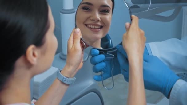 Стоматолог Дает Зеркало Жизнерадостному Пациенту Клинике — стоковое видео