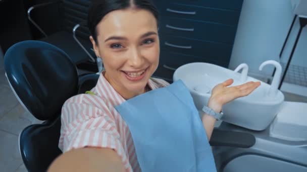 Paciente Sorrindo Falando Acenando Mão Para Câmera Cadeira Dentária — Vídeo de Stock