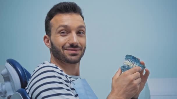 Sorridente Paziente Che Tiene Denti Modello Mostrando Pollice Alto Clinica — Video Stock