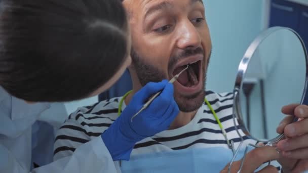 Οδοντίατρος Κρατώντας Οδοντιατρικό Όργανο Κοντά Στον Καθρέφτη Του Ασθενούς Στην — Αρχείο Βίντεο