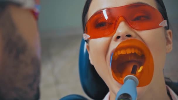 安全ゴーグルで患者と作業しながら歯科治療用ライトを使用して医師 — ストック動画