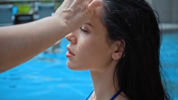 化妆师在游泳池附近的黑发女人上涂面部粉底 — 图库视频影像