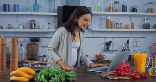 Gravid Kvinna Som Har Videosamtal Laptop Nära Grönsaker Köksbordet — Stockvideo