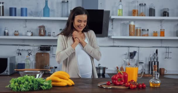 Mujer Embarazada Comiendo Plátano Cerca Verduras Mesa Cocina — Vídeos de Stock