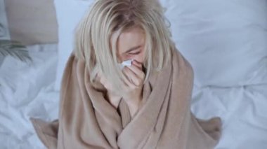 Hasta kadın battaniyeye sarılmış peçeteye hapşırıyor ve vücut ısısını ölçüyordu.