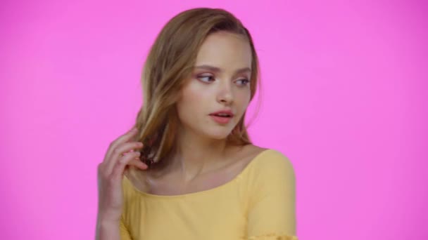 Sonhador Jovem Mulher Tocando Cabelo Enquanto Posando Isolado Rosa — Vídeo de Stock