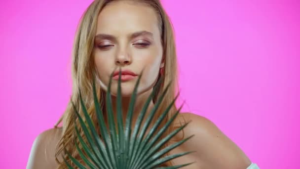 Retrato Jovem Mulher Tocando Rosto Com Folha Palma Isolada Rosa — Vídeo de Stock