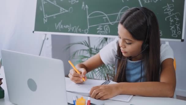 Schoolmeisje Headset Schrijven Terwijl Online Studeren Thuis — Stockvideo