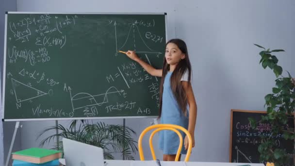 Kid Holding Pen Terwijl Het Tonen Van Wiskunde Formules Schoolbord — Stockvideo