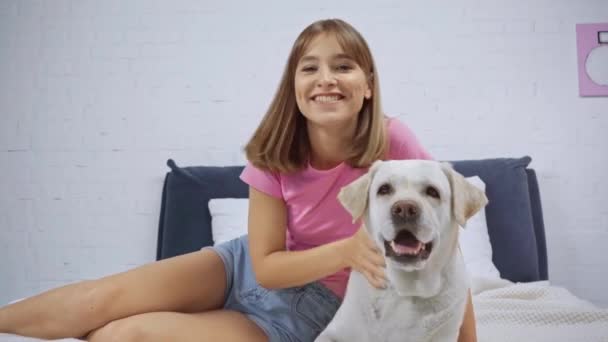 Mujer Joven Saludando Mano Abrazando Golden Retriever Dormitorio — Vídeo de stock