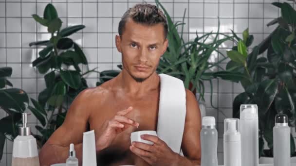 Homem Aplicando Creme Facial Banheiro — Vídeo de Stock