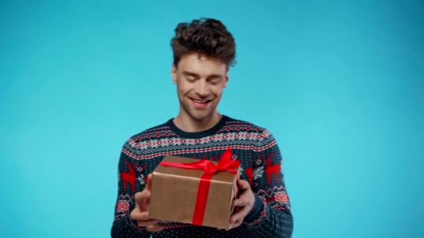 Счастливый Молодой Мужчина Держит Подарочную Коробку Показывает Жест Синий — стоковое видео
