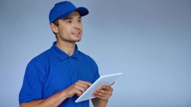 Gri üzerine sipariş verirken dijital tablet kullanan başlıklı teslimatçı
