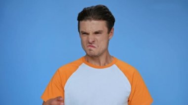 Hoşnut olmayan bir koku ve mavi bir burnu olan hoşnutsuz bir adam.