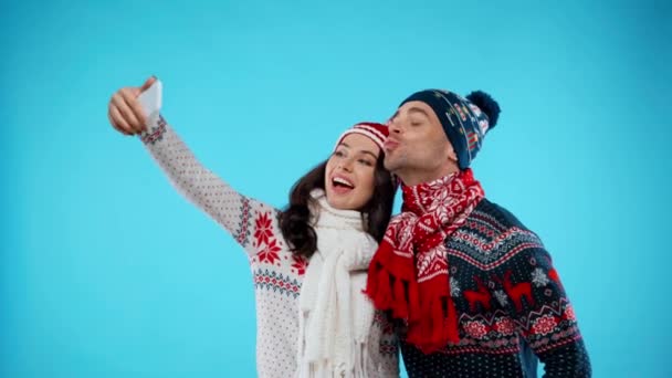 Szczęśliwa Para Kapeluszach Szalikach Robi Selfie Pokazuje Grimaces Niebiesko — Wideo stockowe