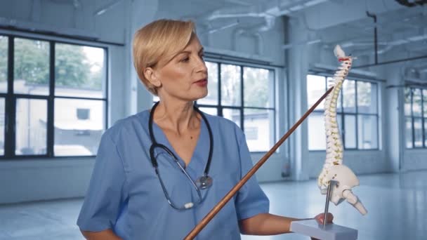 Médico Mediana Edad Hablando Sosteniendo Palillo Apuntando Cerca Del Esqueleto — Vídeo de stock