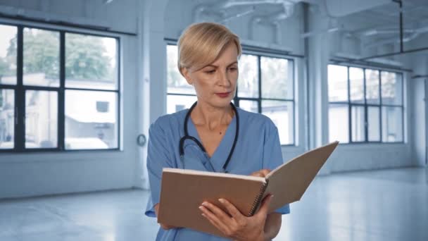 Médico Rubio Mediana Edad Leyendo Recetas Cuaderno — Vídeo de stock