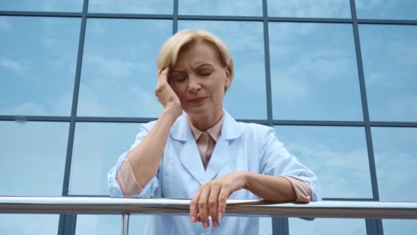 Niski Kąt Widzenia Zmęczonego Lekarza Średnim Wieku Migreną Zewnątrz — Wideo stockowe
