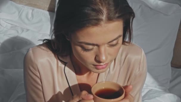 Femme Joyeuse Boire Thé Tout Étant Assis Dans Lit — Video