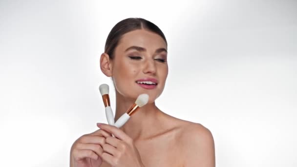 Sonriente Mujer Adulta Joven Posando Mientras Sostiene Cepillos Cosméticos Blanco — Vídeos de Stock