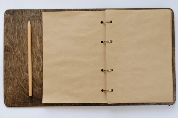 Bloc-notes artisanal ouvert avec couverture en bois et un crayon sur fond blanc. Maquette avec espace pour votre texte — Photo
