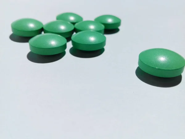 Green pills on a white background. Health care. Medical concept. Medication intake. Copy space