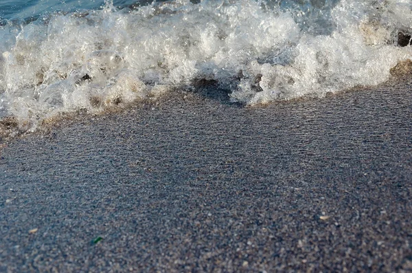 Close-up van zandstrand met zachte inkomende golven. Selectieve focus — Stockfoto