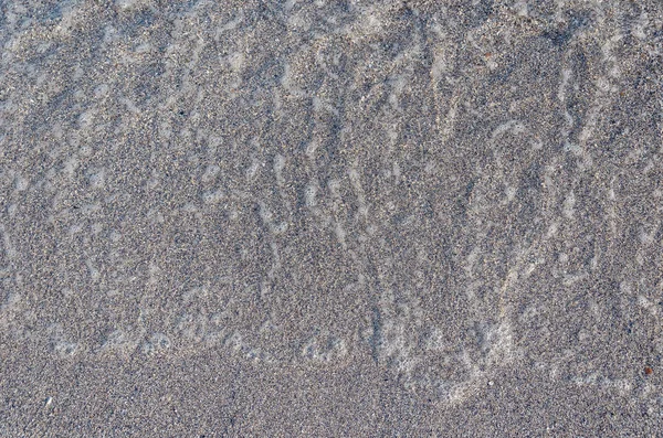 Primer plano de playa de arena con suaves olas entrantes. Enfoque selectivo — Foto de Stock
