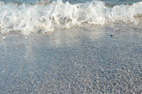 Крупный план песчаного пляжа с мягкими входящими волнами. Селективный фокус — стоковое фото